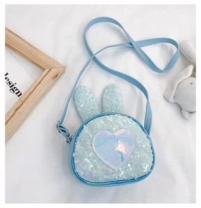 Macro detail of cute light blue rabbit crossbody bag with sequins and heart patches