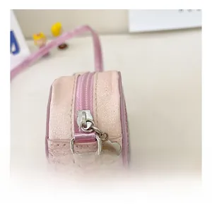 Detailed macro view of pink glitter heart bag with silver flower zipper and metallic strap