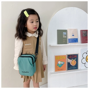Detail of teal waterproof canvas kids crossbody bag with black adjustable strap and zipper