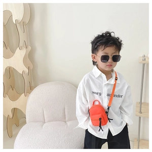 Detail shot of bright orange mini canvas crossbody bag and black square sunglasses for kids