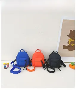 Detailed flat lay of mini canvas crossbody bags in blue, orange, and black colors
