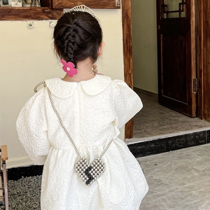 Fashionable girls heart pearl crossbody bag paired with a white puff sleeve princess dress