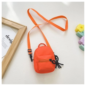 Detailed view of an orange mini crossbody bag with black metal zippers and woven side knot