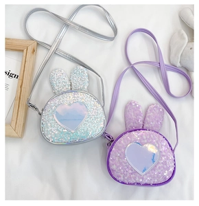 Detail of glitter rabbit ear bags in purple and silver with heart-shaped laser patches