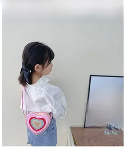 Detail view of pink heart-shaped sequin crossbody bag worn by a child from a side angle