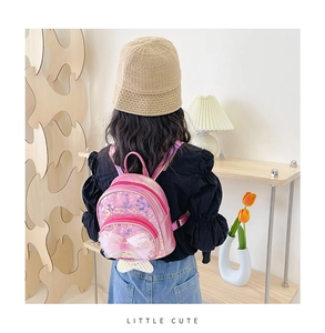 Détail d'un sac à dos rose à paillettes pour enfant avec nœud et queue de sirène