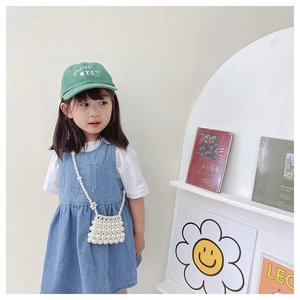 Detail of beaded mini bag with pearls and a blue denim jumper dress set for girls
