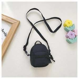 Detail of mini black canvas crossbody bag with front zipper pocket for kids