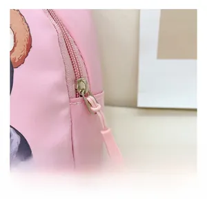 Detailed close-up of the silver metal zipper and pink puller on the cute bear crossbody bag