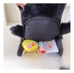 Interior view of black plush backpack showing storage space for phone and accessories