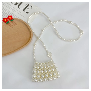 Macro detail of hand-woven mini pearl crossbody bag with beaded texture and elegant finish
