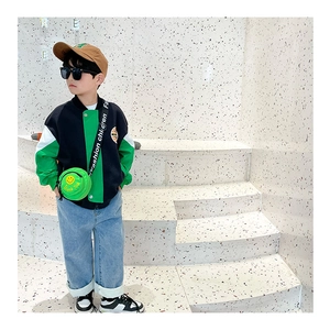 Detail eines Kindes mit grüner Smiley-Canvas-Umhängetasche und Baseball-Jacke-Outfit
