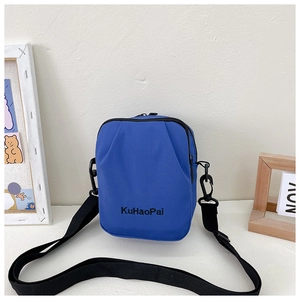 Detail showing royal blue canvas crossbody bag with black embroidery and adjustable strap