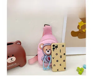 Pink cartoon bear crossbody bag detail showing compact size compared to a mobile phone