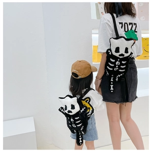 Detail view of plush black cat skull backpacks in adult and child sizes for family travel