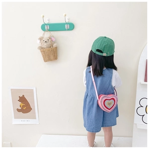 Pink sequin heart-shaped kids crossbody bag with glitter details shown on a model