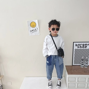 Mini minimalist canvas crossbody bag for children shown in a stylish street style outfit