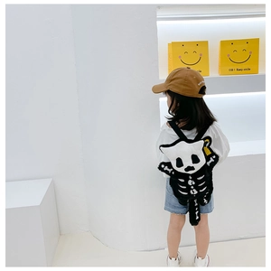 Detail of cute black plush toddler backpack with white animal skeleton pattern embroidery