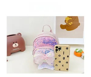 Gros plan du sac à dos rose à paillettes pour enfants avec nœud et témoin de taille