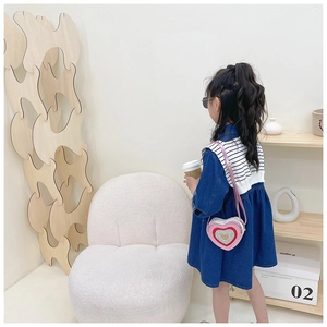 Pink glitter heart-shaped shoulder bag paired with a navy denim dress for girls