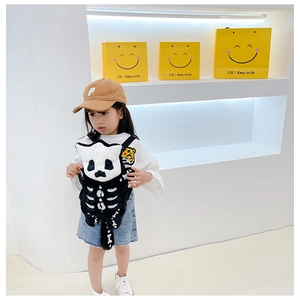 Close-up of plush skull panda backpack and embroidered brown baseball cap for kids