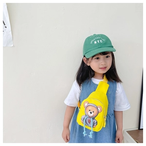 Detail of yellow canvas kids crossbody bag with cute cartoon bear and green cap