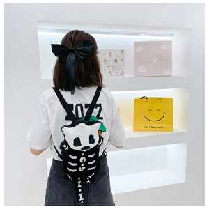 Close-up of a cute gothic plush backpack with skeleton prints and soft faux fur texture