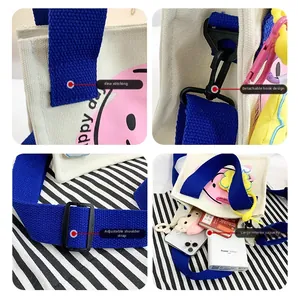 Detail of canvas bag showing adjustable blue strap and pink smiley face print design