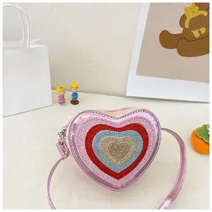 Detail of pink heart-shaped kids crossbody bag with vibrant glitter layers and silver zipper