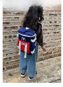 Detail view of durable navy and red contrast nylon backpack with NY letter embroidery