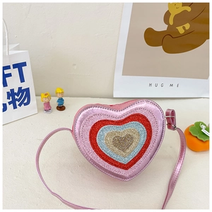 Detailed view of pink metallic heart-shaped crossbody bag with glitter heart patterns
