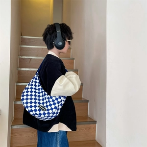 Blue and white checkerboard crossbody bag with crescent shape and fashion logo