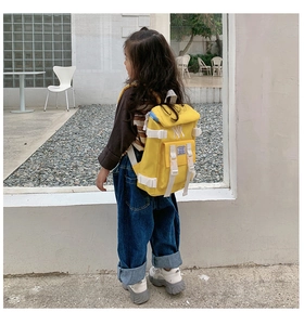 Close-up of yellow nylon kids backpack featuring white NY embroidery and buckle detail