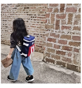 Close-up of lightweight nylon kids backpack with NY logo and tote bag with LA logo