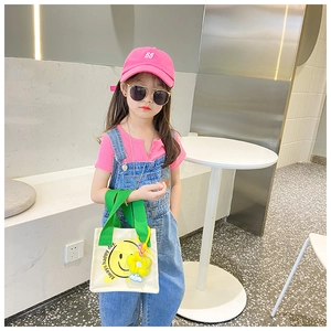 Kids mini canvas tote bag featuring a yellow smiley face print and green handles