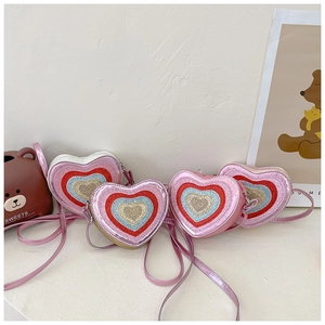 Detail view of colorful heart-shaped sequin crossbody bags for kids in four bright shades