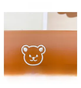 Close-up of white bear embroidery and stitching detail on a brown leather kids backpack