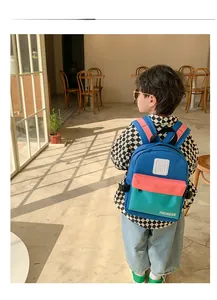 Sac à dos enfant bleu et rose contrasté présenté dans un café pour un style décontracté