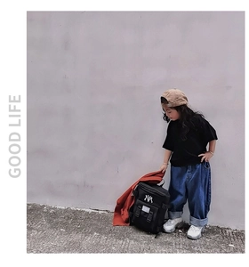 Detail of a black nylon kids backpack featuring white NY embroidery for outdoor activities