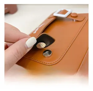 Detail of magnetic metal buckle closure on brown leather vintage child's backpack