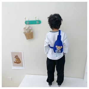 Rear view of child wearing blue bear print chest bag with adjustable strap and zipper