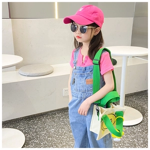 Toddler outdoor outfit featuring pink t-shirt, denim overalls and smiley face canvas bag