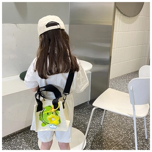 Kids smile canvas crossbody bag with sunflower charm and black straps on model back
