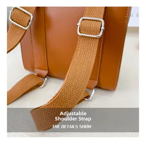Detail of adjustable shoulder strap with metal buckle on brown vintage leather backpack