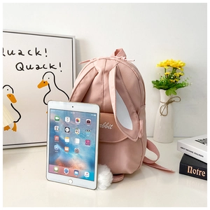 Pink rabbit backpack size comparison with a tablet, featuring cute 3D ears and pom-pom