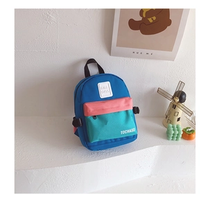 Détail d'un sac à dos pour enfant avec design color-block bleu et rose et logo
