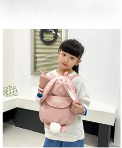 Detailed view of pink rabbit backpack with long ears and soft plush ball for kids