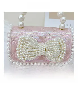 Detail of pink iridescent quilted mini bag with pearl bow and white lace trim edge