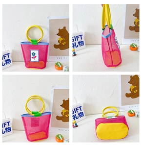 Detail of colorful mesh beach bag for kids with yellow round handles and floral patch
