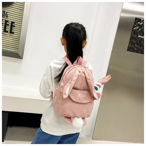 Rear view of a pink toddler backpack with 3D rabbit ears and a white pom-pom tail detail